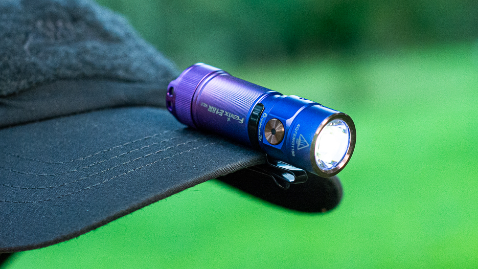 Fenix E18R V2.0 pričvršćen na šilt kape.